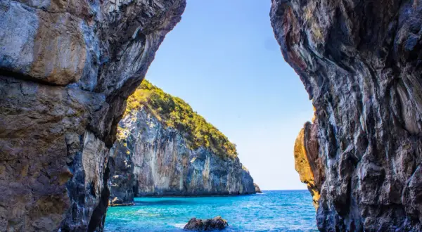 Vista da una grotta su un mare cristallino e una scogliera verdeggiante. Un vero paradiso, tra le scalea spiagge più belle.