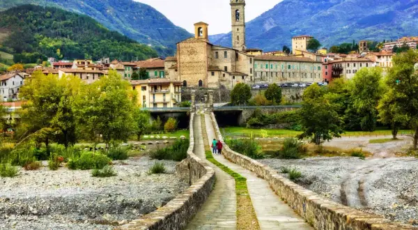 Bobbio, borgo dei borghi, con il suo ponte romano e la torre campanaria che domina il paesaggio collinare.