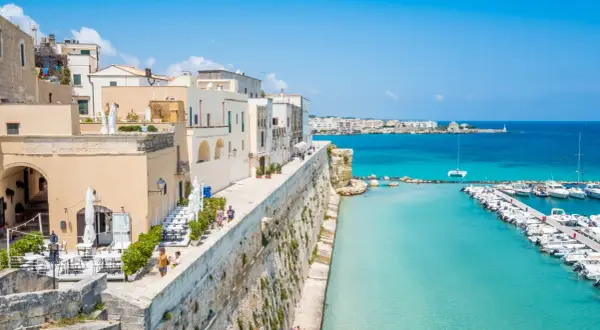 Otranto cosa vedere: un borgo bianco affacciato sul mare turchese, con un porto pieno di barche e un lungomare da sogno.