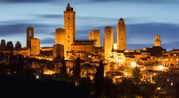 San Gimignano, una delle città da visitare in Toscana, illuminata di notte con le sue iconiche torri medievali.