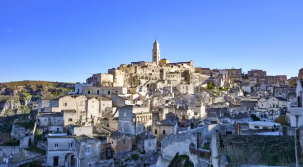 Panoramica dei Sassi di Matera, un labirinto di case scavate nella roccia, con indicazioni visive che guidano attraverso questo sito UNESCO.