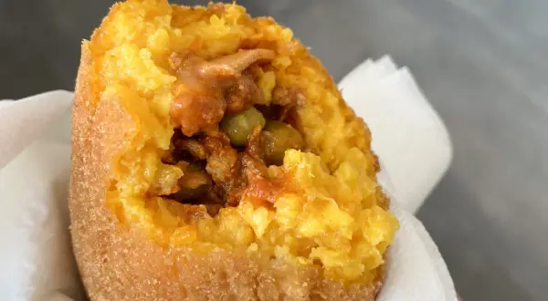 Arancino al ragù, un classico da provare se ti chiedi cosa mangiare a Catania. Croccante fuori, saporito dentro.