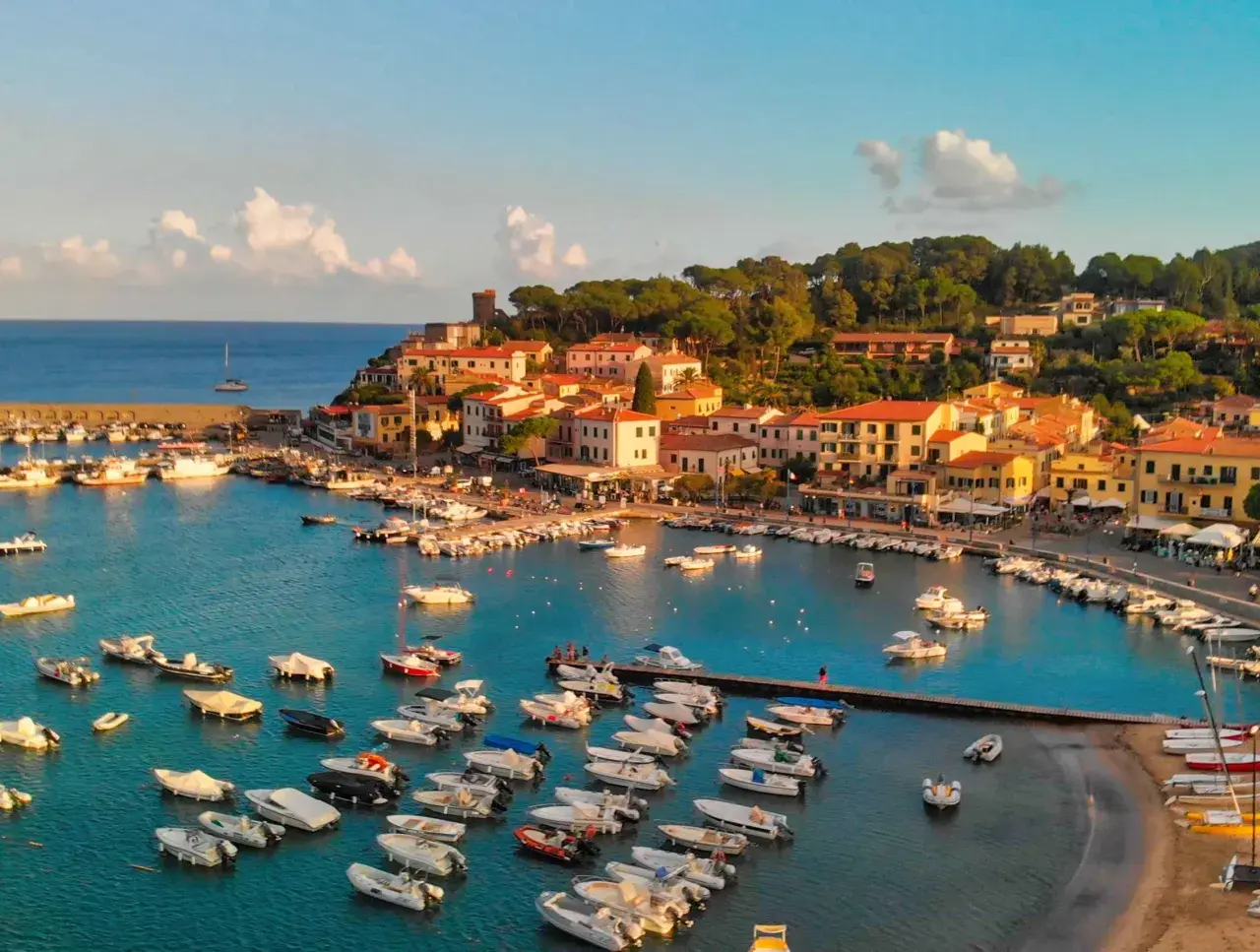 Porto con barche e case colorate, un luogo incantevole da scoprire: isola d'Elba cosa vedere.