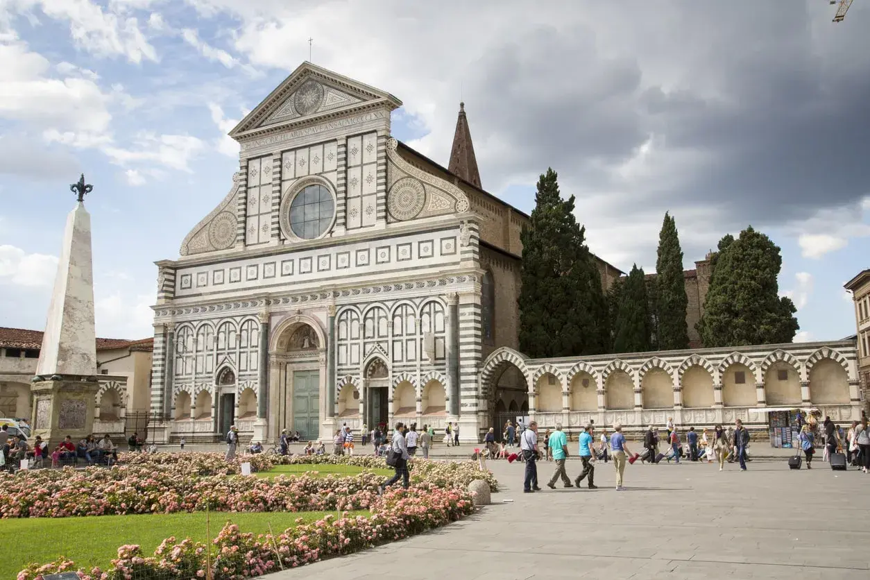 Piazza Santa Maria Novella, uno dei luoghi da vedere a Firenze, con la sua facciata rinascimentale e un prato fiorito.
