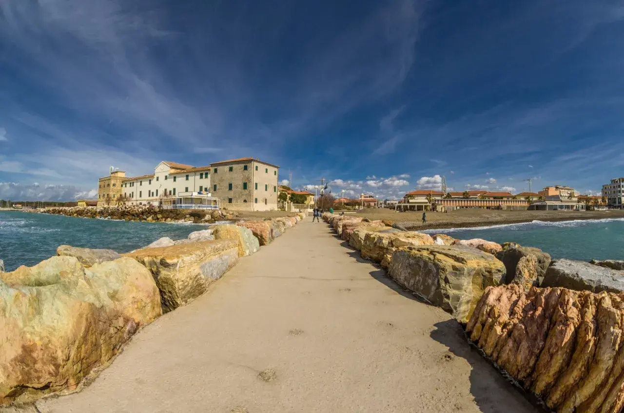 Passeggiata sul molo di Marina di Cecina, con edifici storici e stabilimenti balneari. Cosa vedere in questo angolo di Toscana.