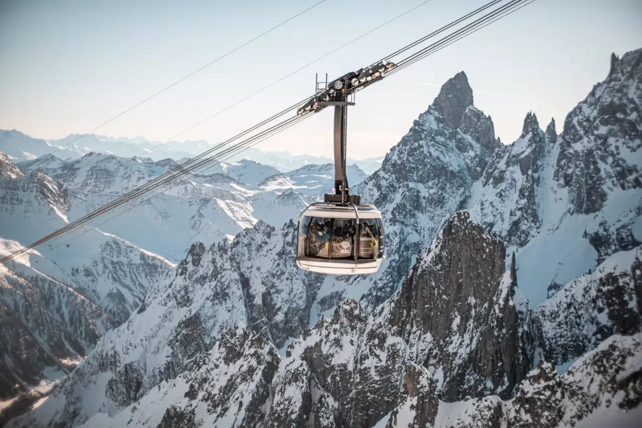 Cabina della funivia sorvola montagne innevate, un'esperienza imperdibile per scoprire Courmayeur cosa vedere.