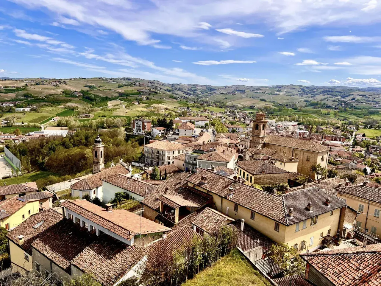 Panoramica di Castagnole delle Lanze, con tetti rossi e colline verdi. Cosa vedere: il borgo e i vigneti circostanti.