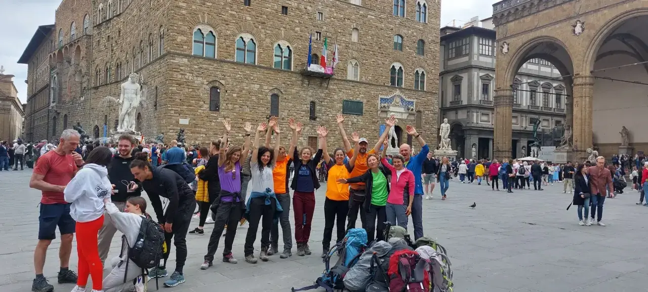 Un gruppo di escursionisti festeggia a Firenze, pronto per le tappe della Via degli Dei.