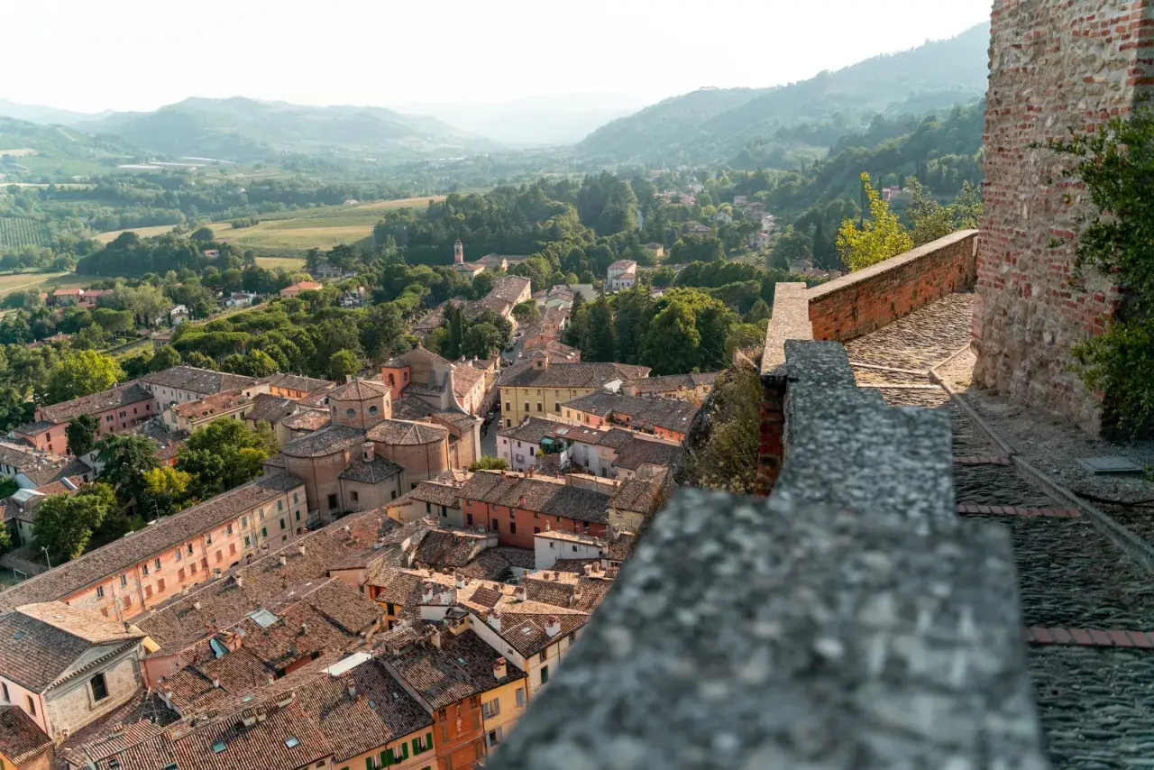 Panoramica di un borgo da visitare in Romagna, con tetti in cotto e colline verdi sullo sfondo.