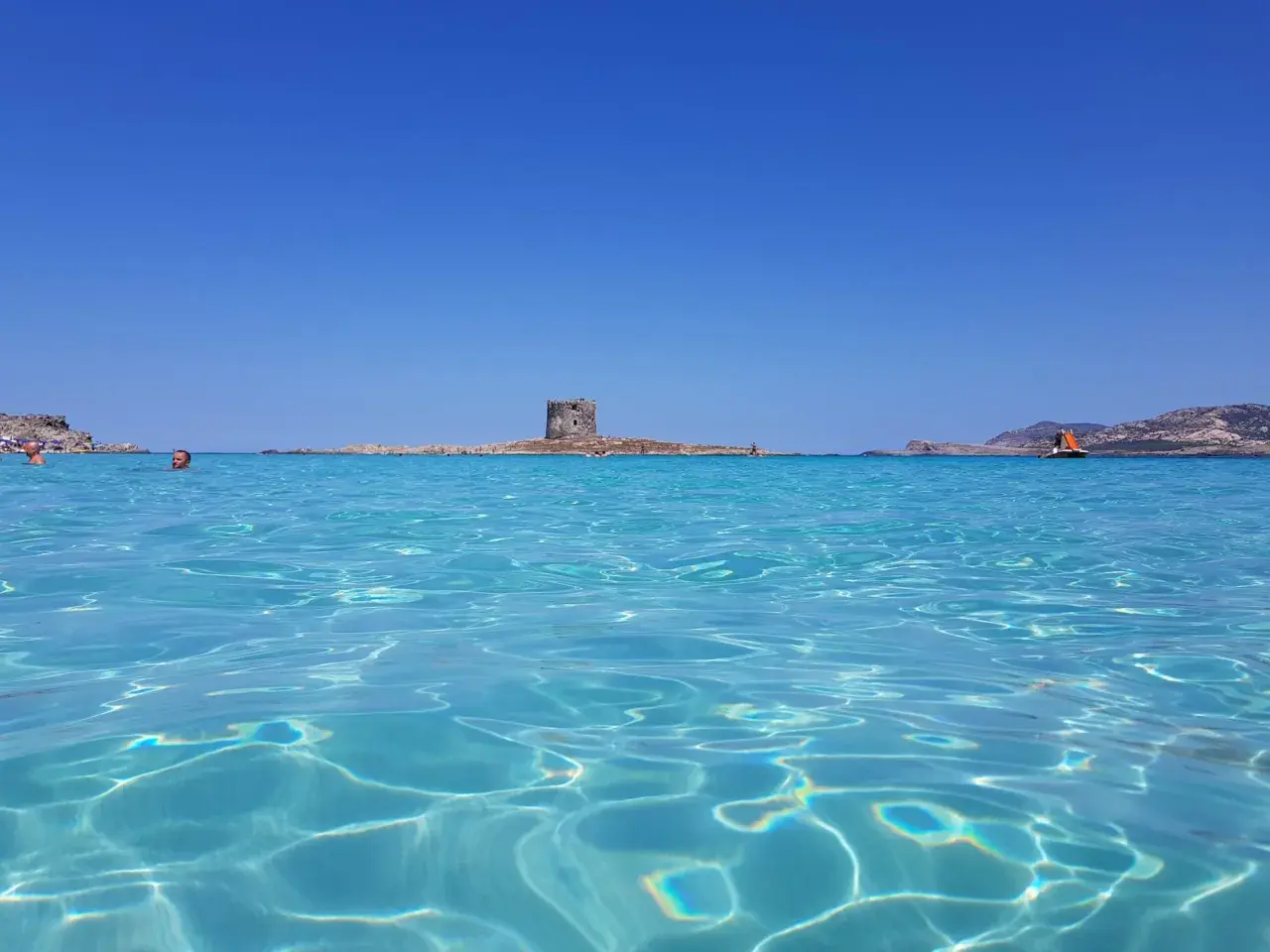 Acque cristalline e un'antica torre in mezzo al mare: uno dei tanti posti di mare belli in Italia.
