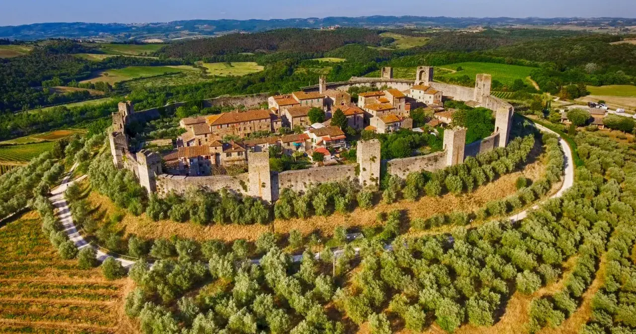 Borgo medievale fortificato in Toscana, circondato da uliveti e colline verdi. Un gioiello tra i borghi da visitare in Toscana.