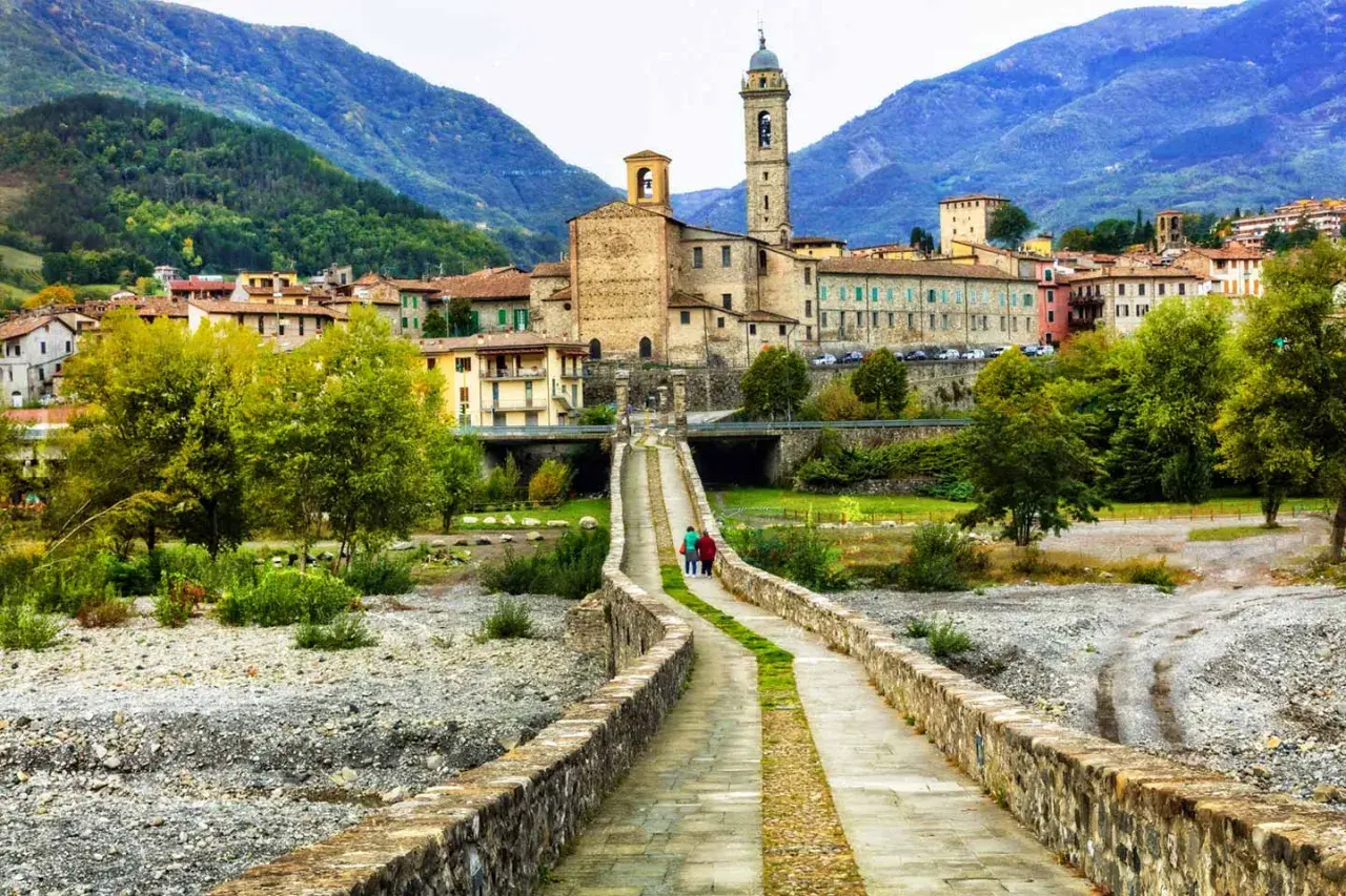 Bobbio, borgo dei borghi, con il suo ponte romano e la torre campanaria che domina il paesaggio collinare.