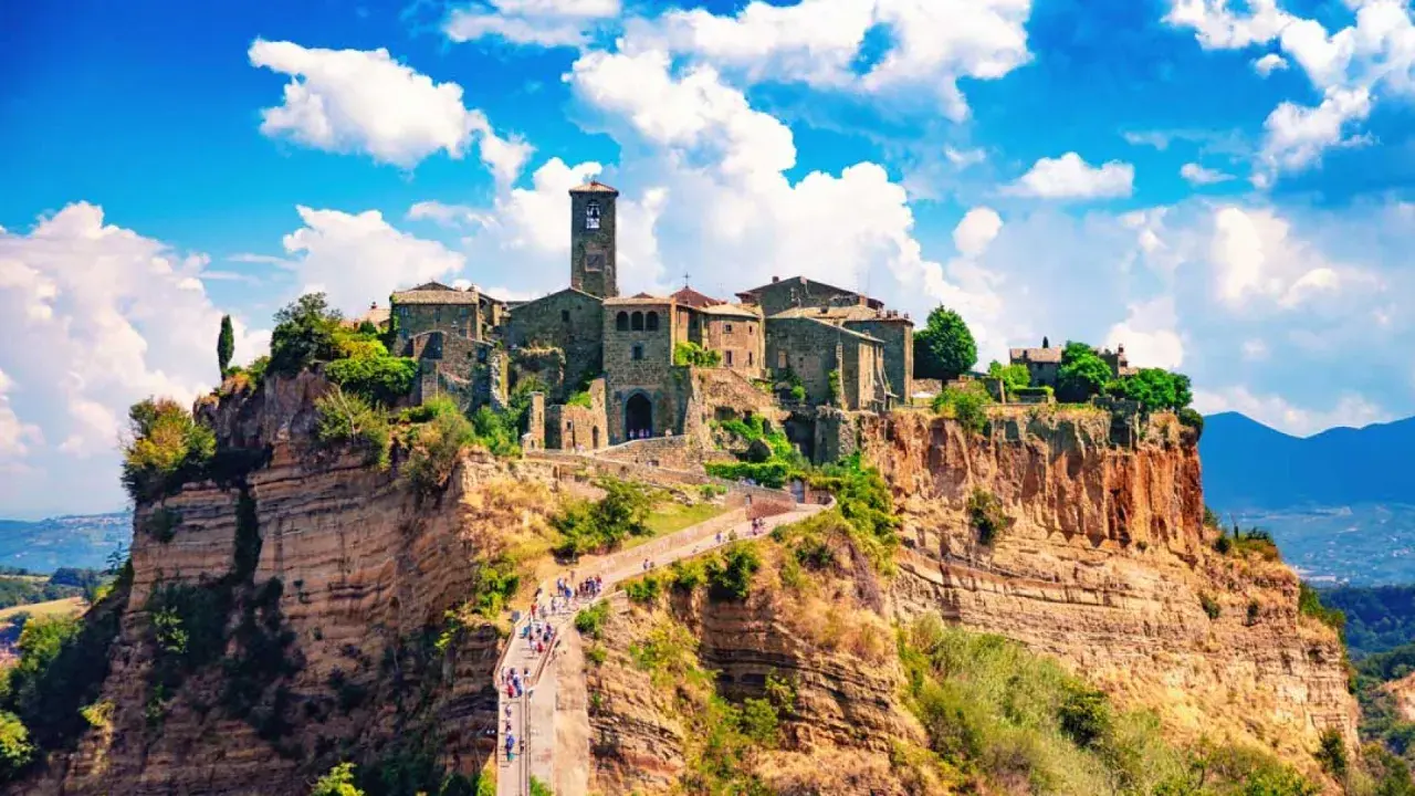 Civita di Bagnoregio, un borgo arroccato su uno sperone di tufo, accoglie i suoi pochi abitanti e visitatori con un ponte pedonale panoramico.