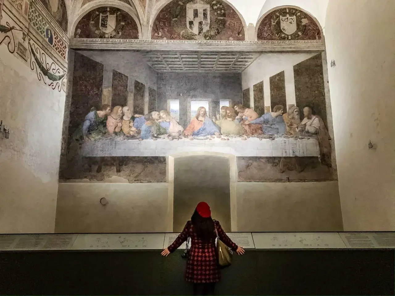 La donna ammira il cenacolo di Leonardo, un'opera d'arte che cattura l'intensità del momento.