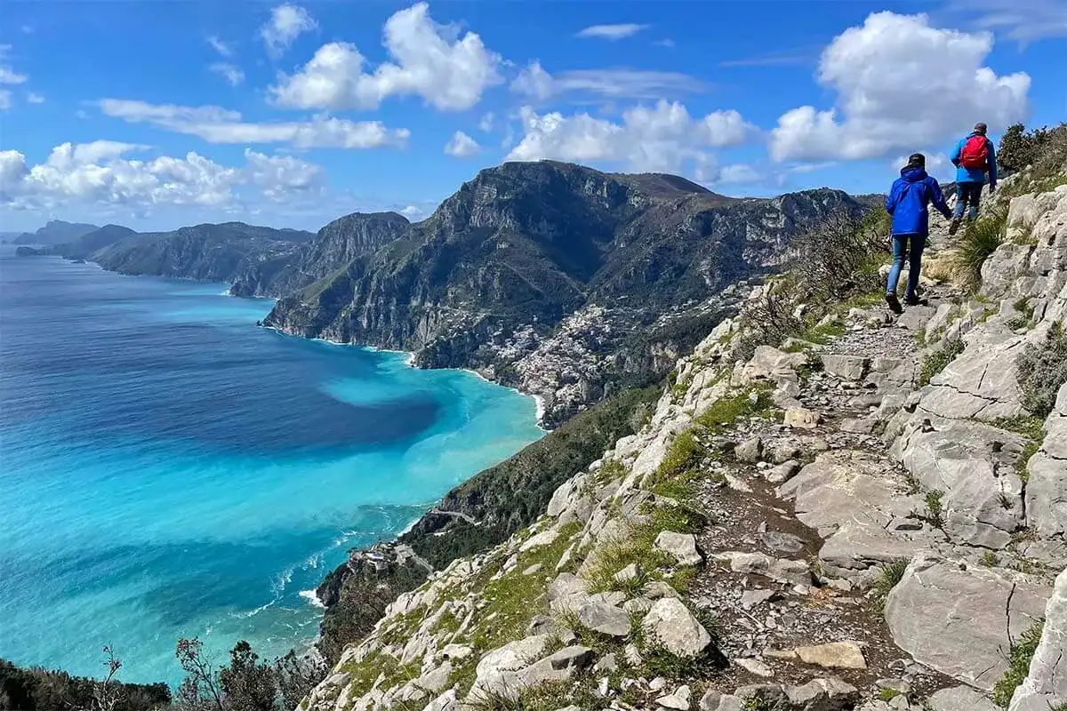 Escursionisti sul sentiero degli dei, con vista mozzafiato sulla costa e sul mare turchese. Una mappa ideale per chi ama l'avventura.