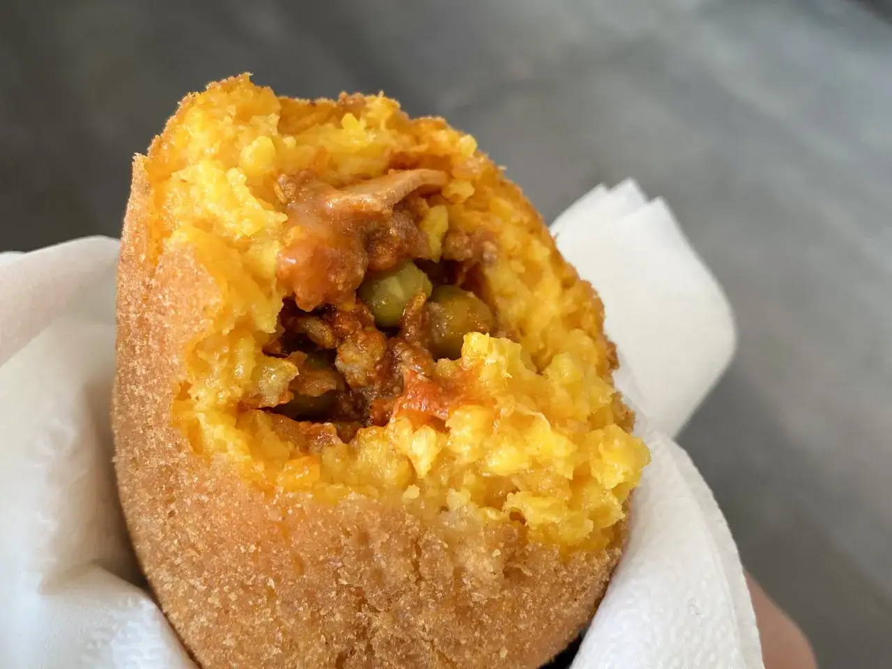 Arancino al ragù, un classico da provare se ti chiedi cosa mangiare a Catania. Croccante fuori, saporito dentro.