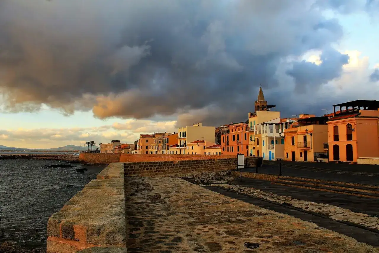 Alghero: case colorate sul lungomare con un cielo tempestoso. Perfetto per scoprire cosa vedere ad Alghero in 3 giorni.