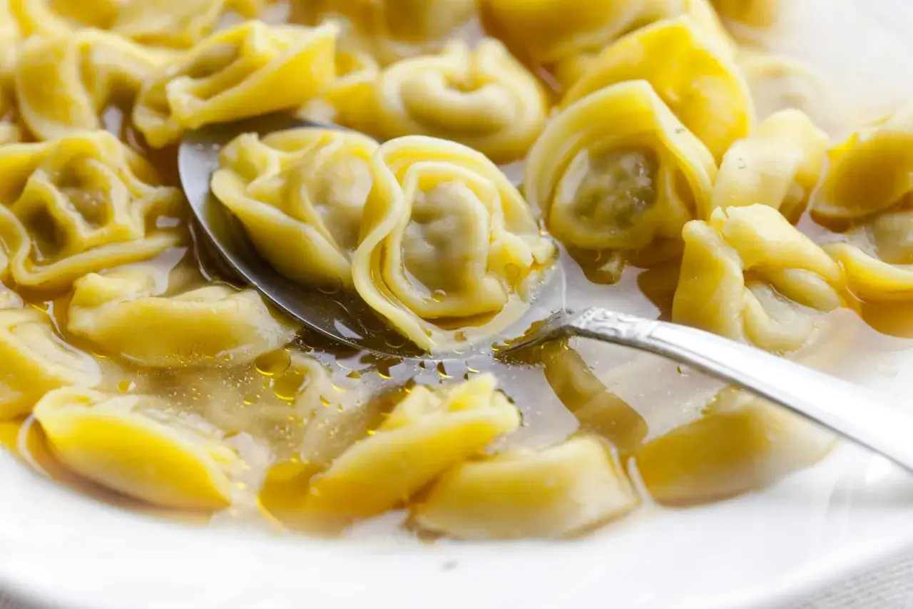 Tortellini in brodo, un classico da provare assolutamente se ti chiedi cosa mangiare a Bologna. Un piatto caldo e confortante.