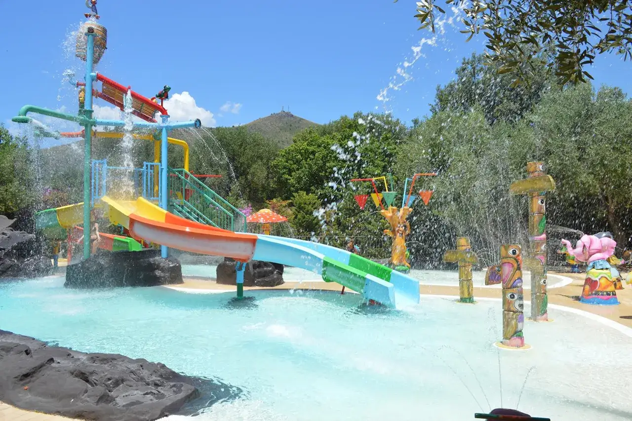 Scivoli colorati e giochi d'acqua in un parco acquatico in Italia, perfetto per rinfrescarsi d'estate.