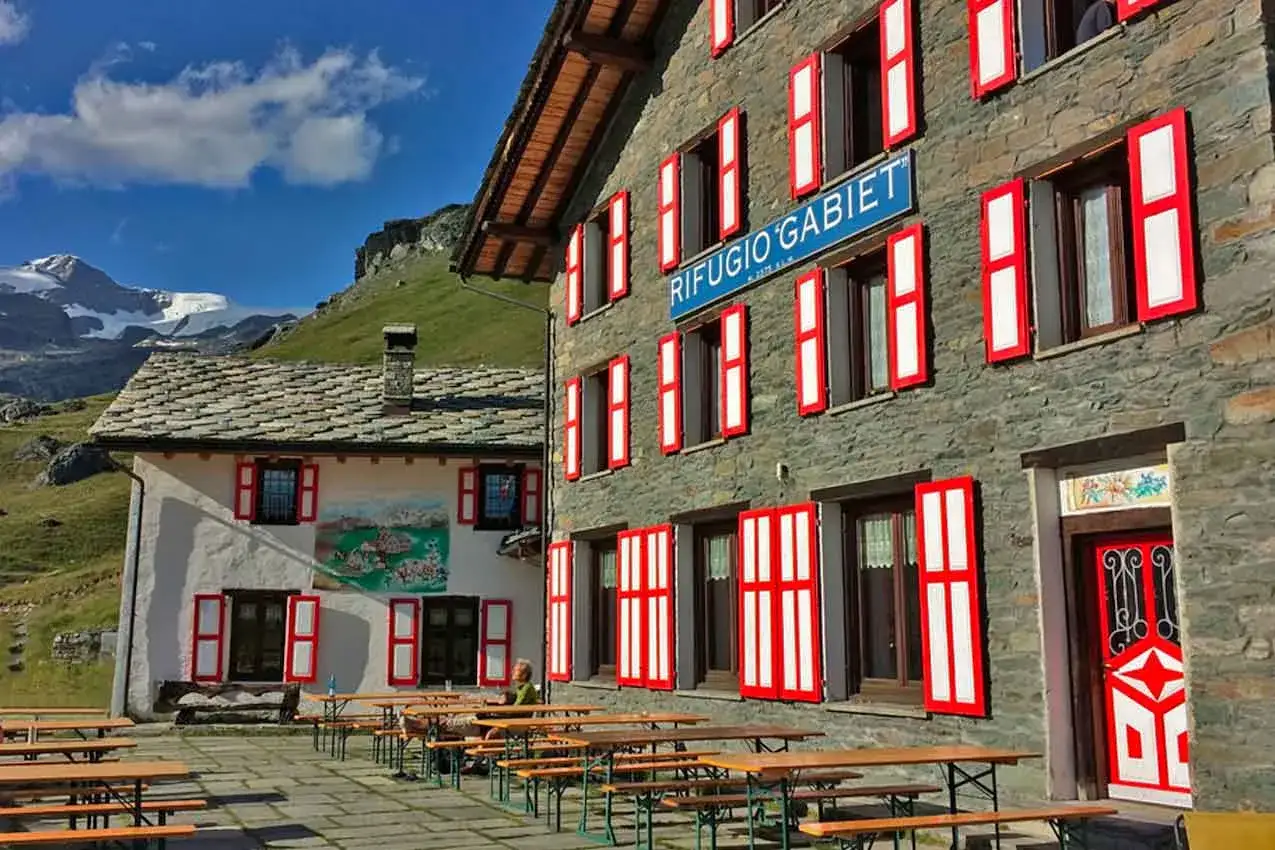 Rifugio Gabiet: come arrivare in questo luogo alpino con tavoli all'aperto e vista sulle montagne innevate.