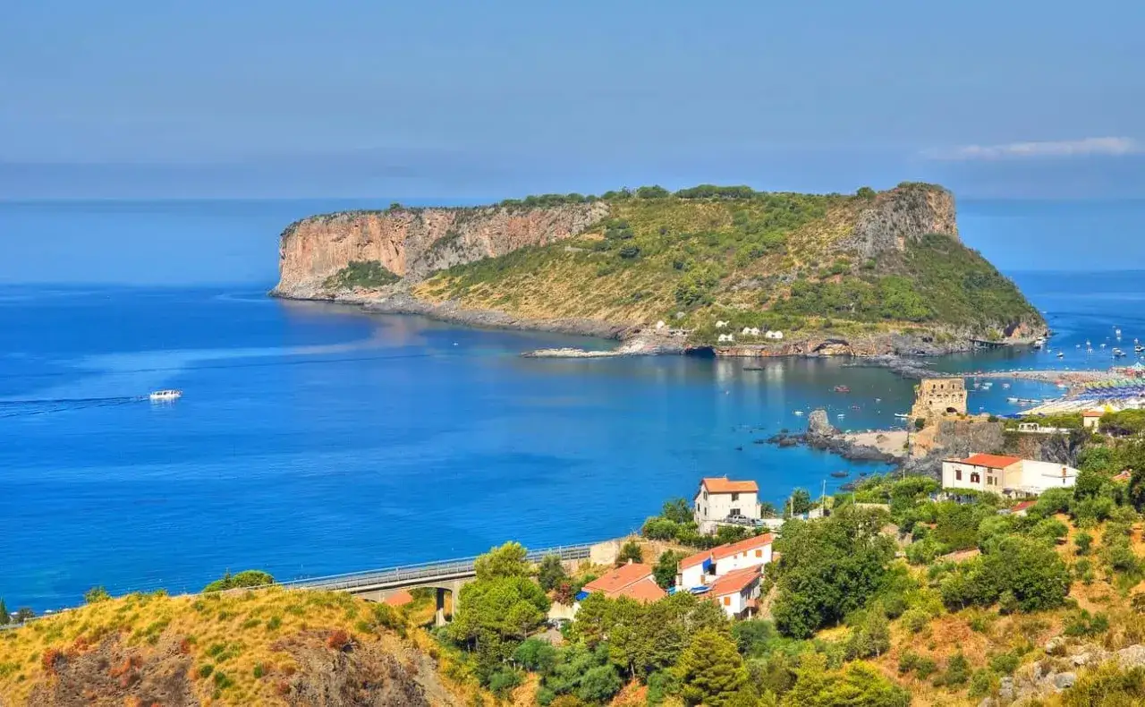 Scogliera verdeggiante e mare blu intenso, un panorama mozzafiato che invita a scoprire i posti da visitare in Calabria.