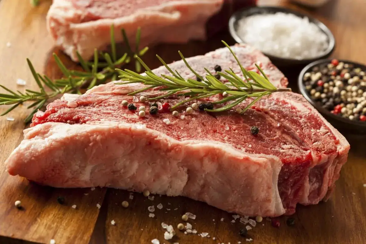 Bistecca alla fiorentina: ecco cosa mangiare a Firenze per un'esperienza culinaria indimenticabile. Carne cruda, rosmarino, sale grosso e pepe.