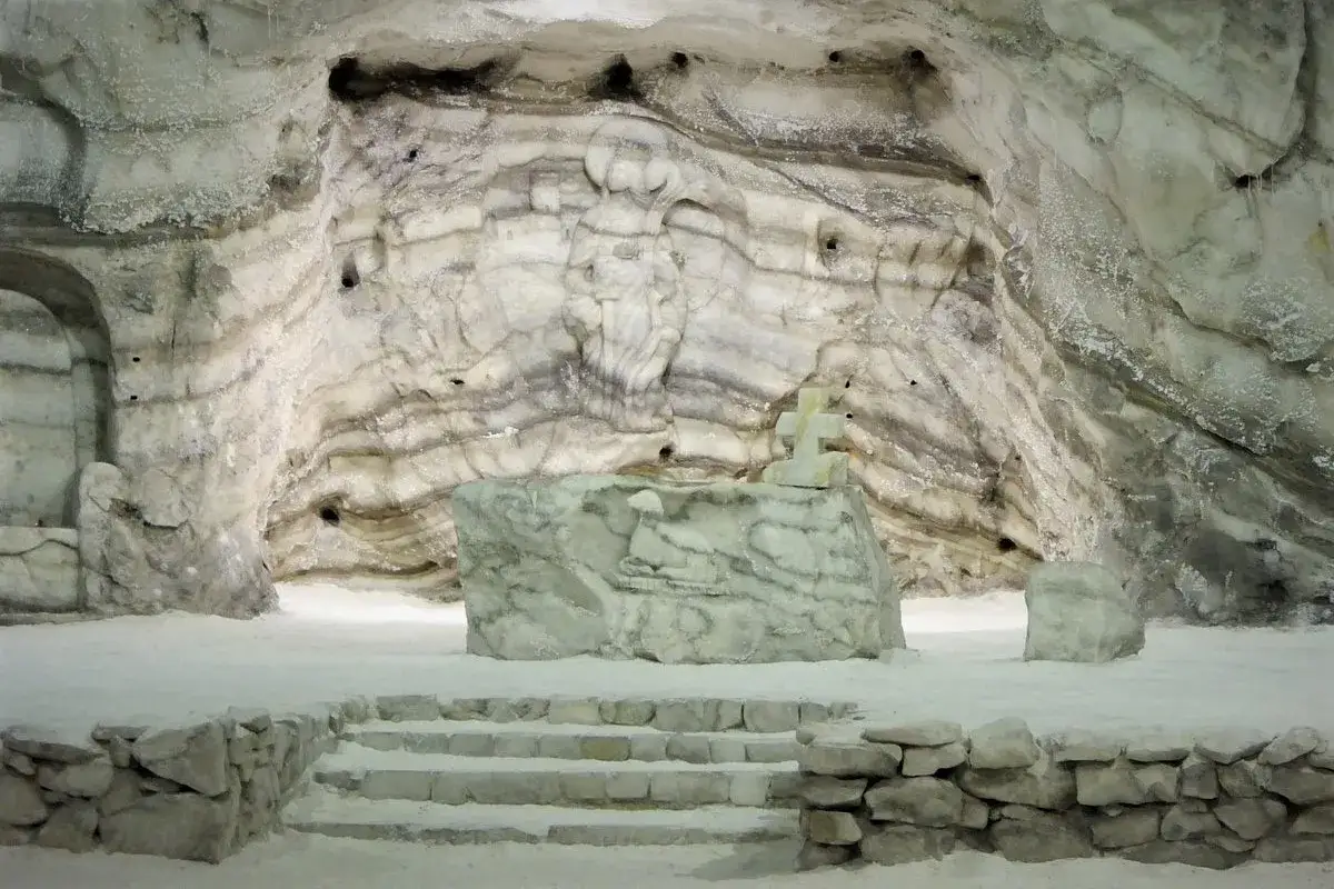 La cattedrale di sale Realmonte, un'opera scavata nel sale, presenta un altare con una croce e un bassorilievo, e una statua scolpita nella parete.