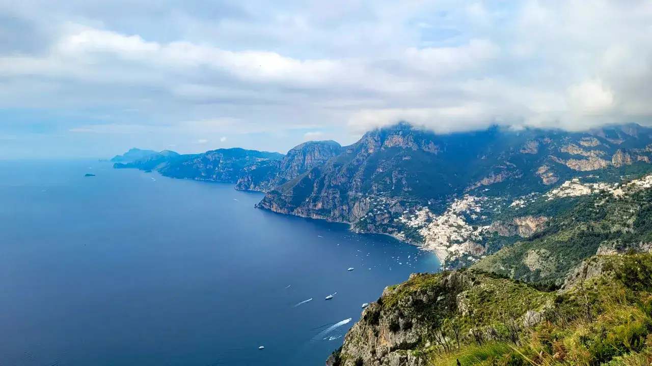 Vista mozzafiato della costa amalfitana, con il mare blu intenso e le case bianche aggrappate ai monti. Un'ottima sentiero degli dei mappa per esplorare questo paradiso.