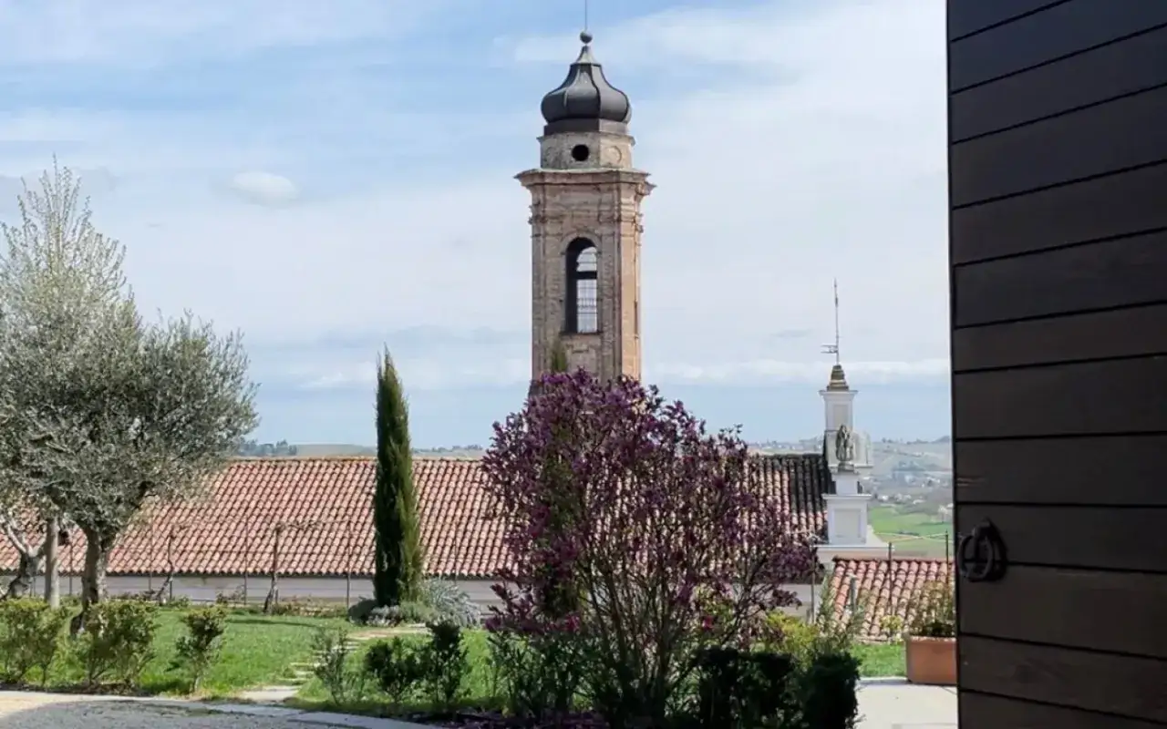 Campanile antico e magnolie in fiore a Castagnole delle Lanze. Un invito a scoprire cosa vedere in questo borgo piemontese.