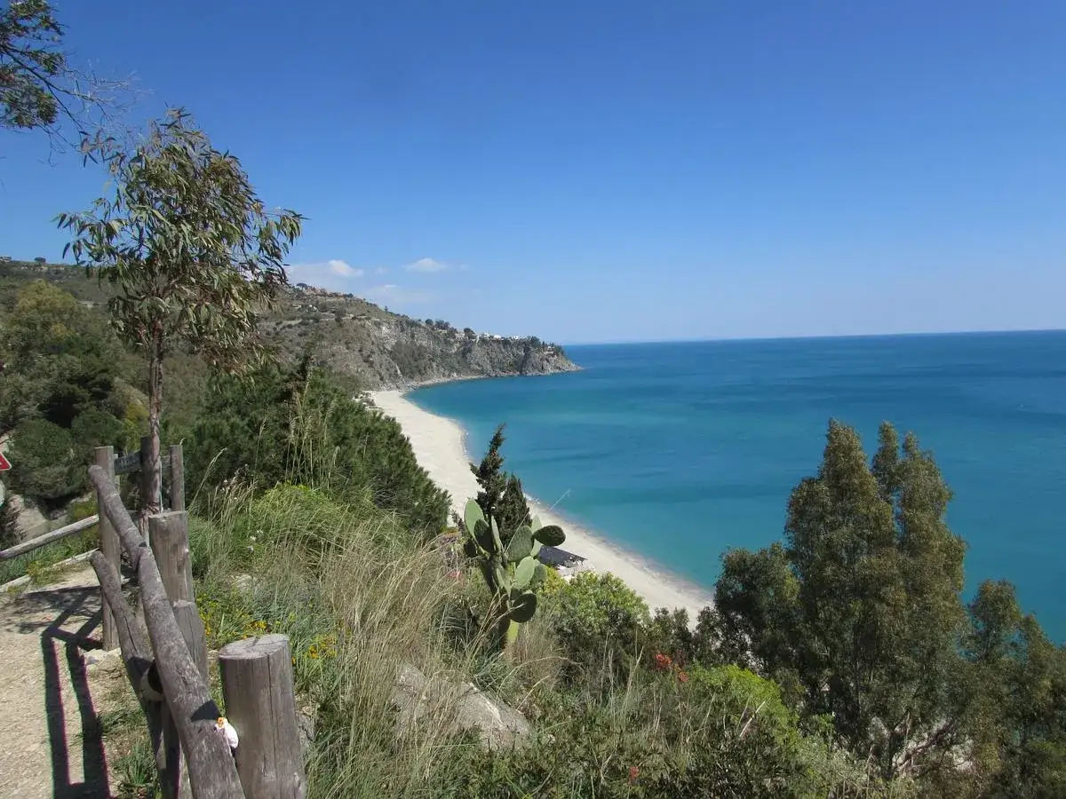 Vista panoramica delle spiagge di Reggio Calabria, con sabbia chiara e mare azzurro sotto un cielo limpido.