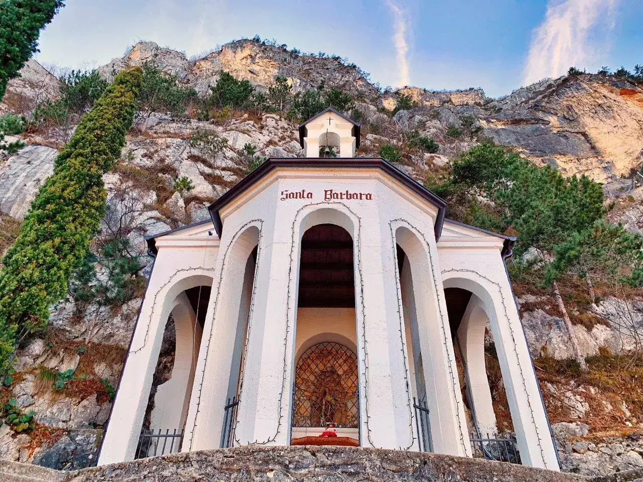 Piccola chiesa bianca a San Martino, incastonata nella roccia, con il nome