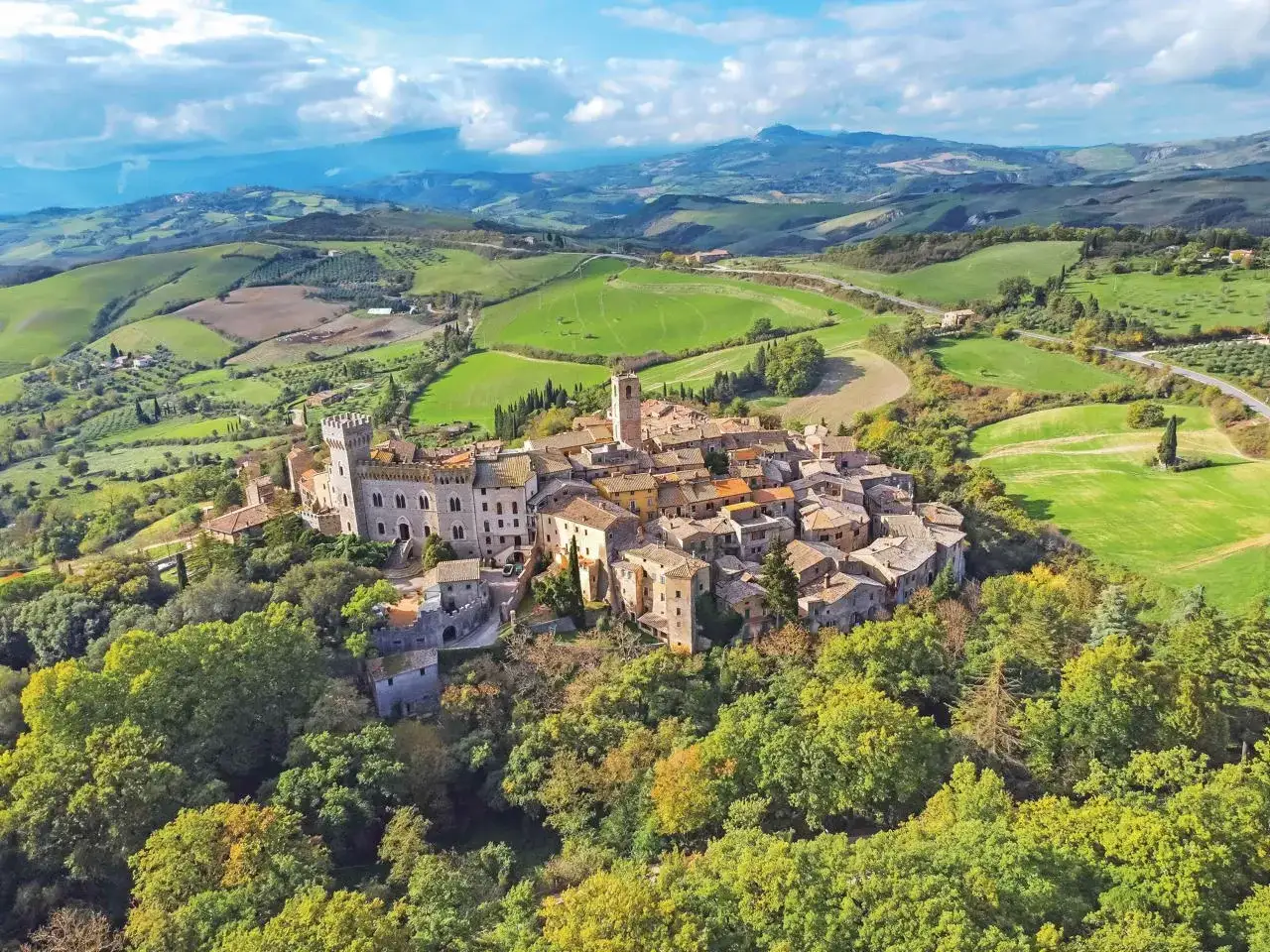 Borgo medievale arroccato su una collina, circondato da dolci colline verdi. Un gioiello della Toscana da visitare.
