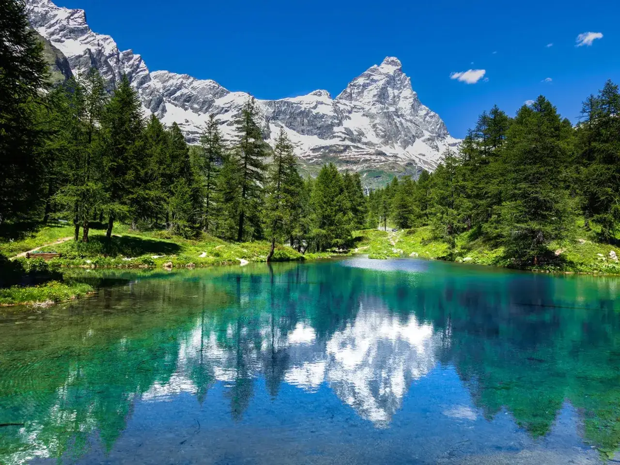 Lago alpino cristallino con riflesso del Cervino, incantevole paesaggio tra Piemonte e Valle d'Aosta.