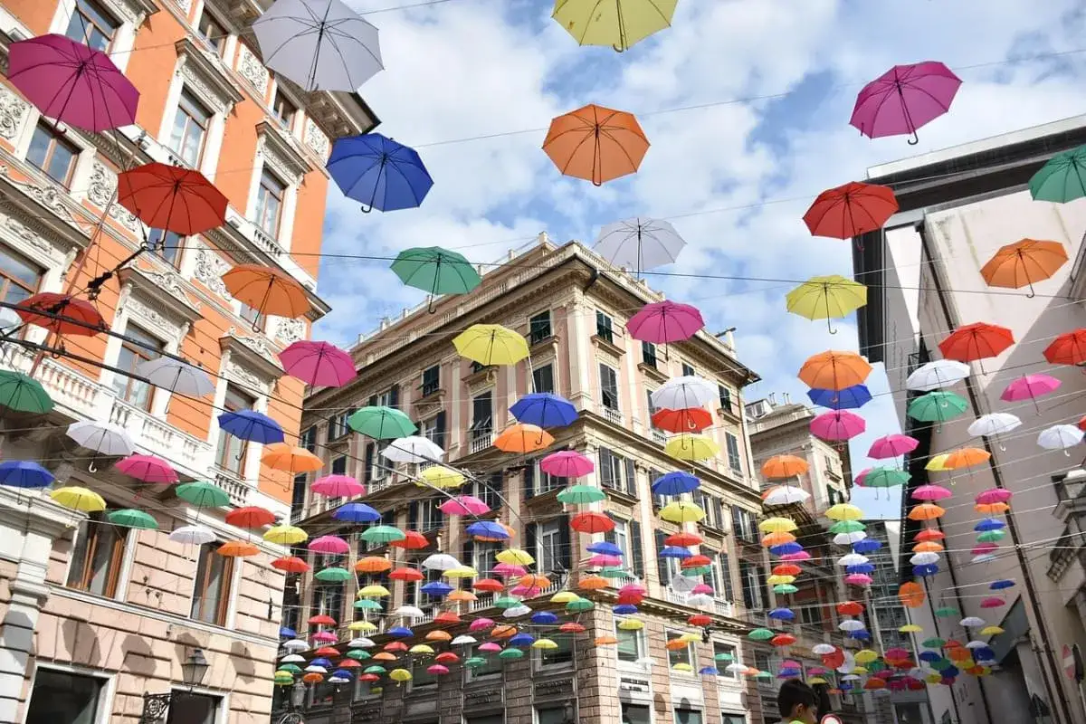 Un cielo di ombrelli colorati illumina le vie, creando luoghi magici per bambini in Italia.