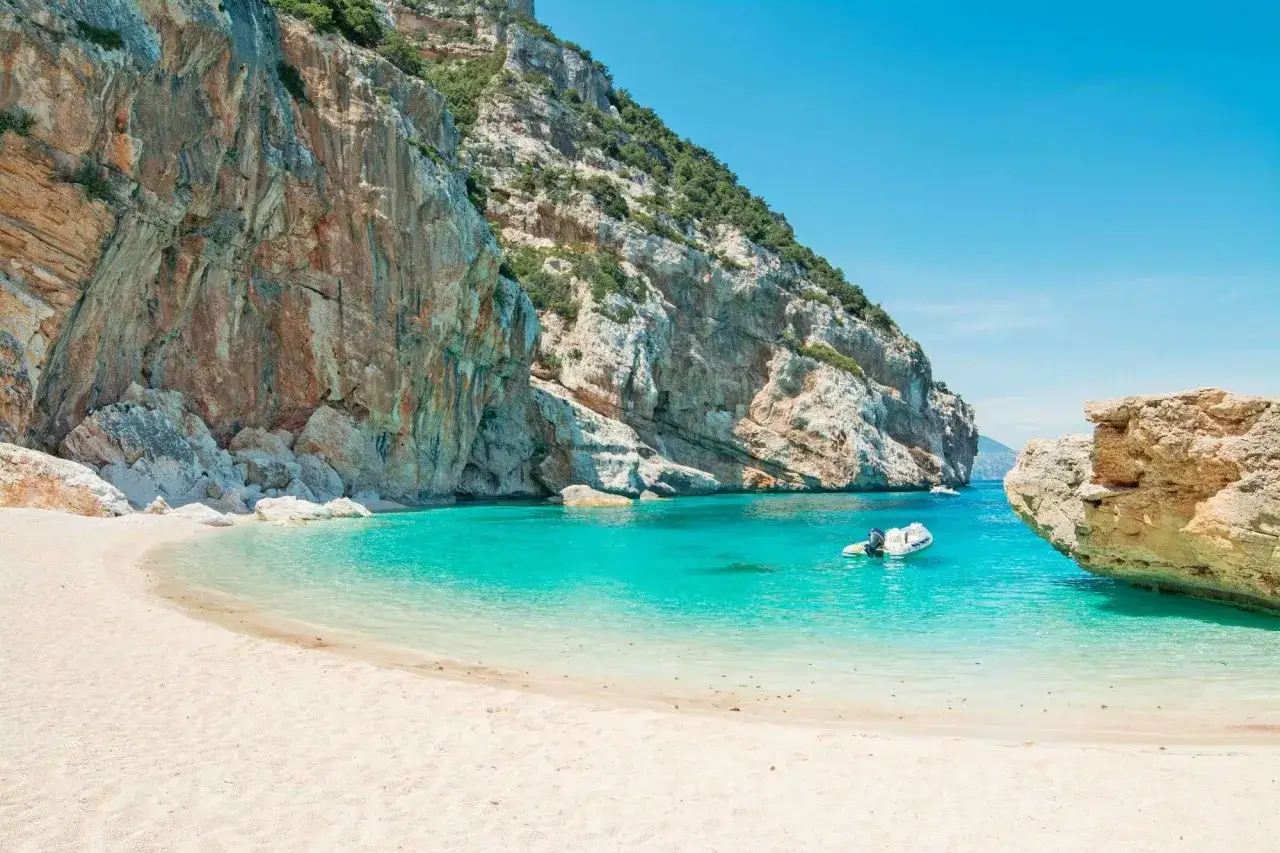 Spiaggia incantevole con sabbia bianca e acque turchesi, incastonata tra imponenti scogliere. Un vero gioiello tra le spiagge più belle della Sardegna.