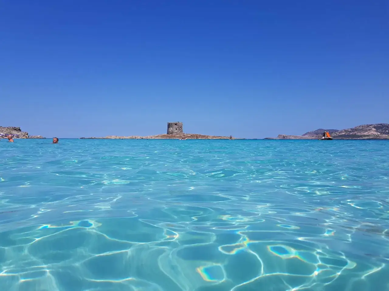 Acque cristalline e un'antica torre in mezzo al mare: uno dei tanti posti di mare belli in Italia.