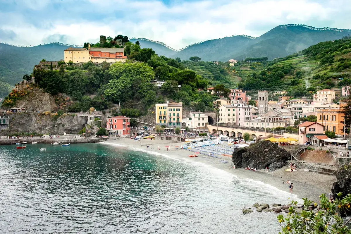 Un borgo colorato a picco sul mare, con una spiaggia e montagne verdi: ecco cosa vedere in Liguria, un vero incanto.