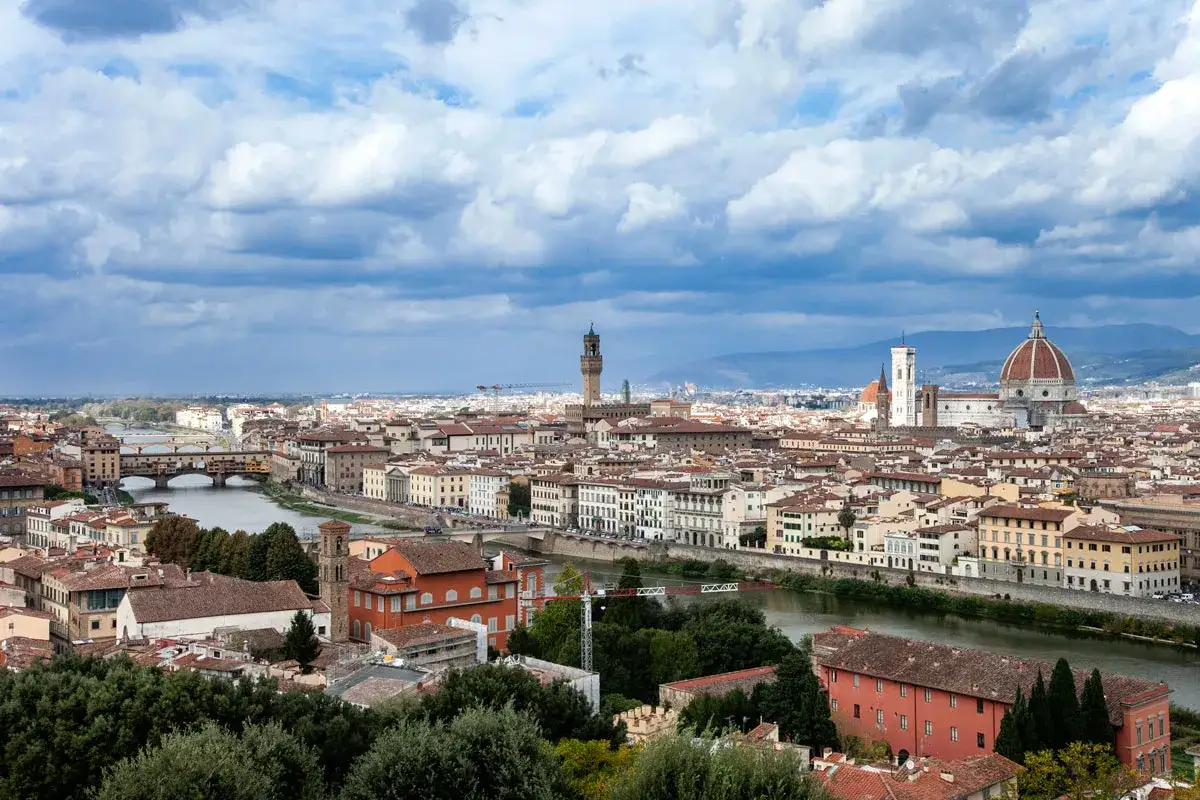 Vista panoramica di Firenze, la capitale della Toscana, con il Duomo, Ponte Vecchio e il fiume Arno sotto un cielo nuvoloso.