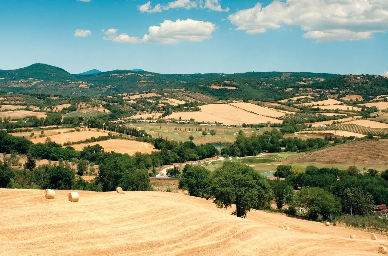 Colline dorate, balle di fieno e cipressi in un paesaggio da cartolina, uno dei tanti posti belli in Toscana.