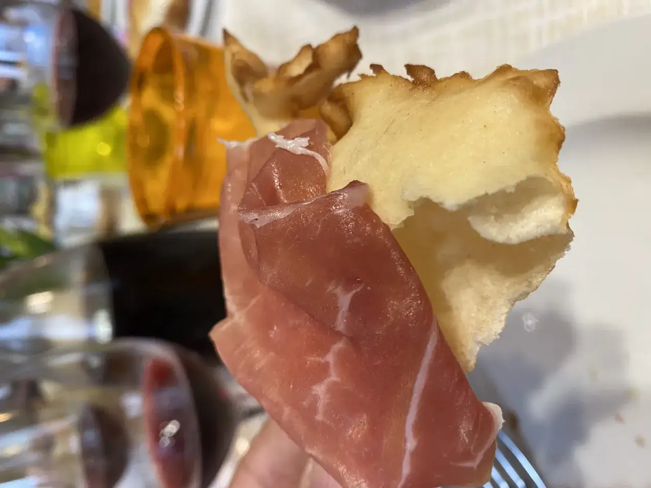 Prosciutto crudo su gnocco fritto, un classico per scoprire cosa mangiare a Parma. Un boccone che sa di tradizione.