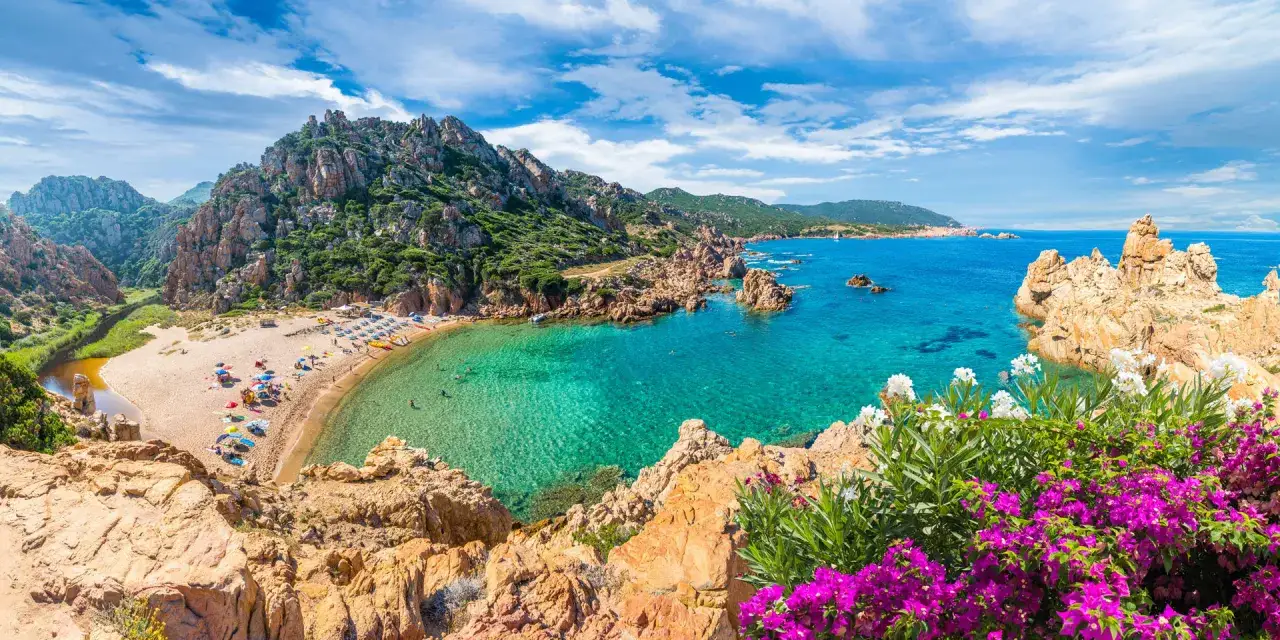 Spiaggia incantevole in Sardegna, tra le zone più belle. Acque cristalline, rocce scolpite e fiori colorati.
