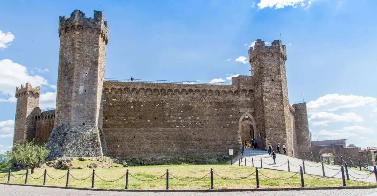 La Fortezza di Montalcino, un luogo imperdibile per scoprire cosa vedere in un giorno, con le sue imponenti torri e mura di pietra sotto un cielo azzurro.