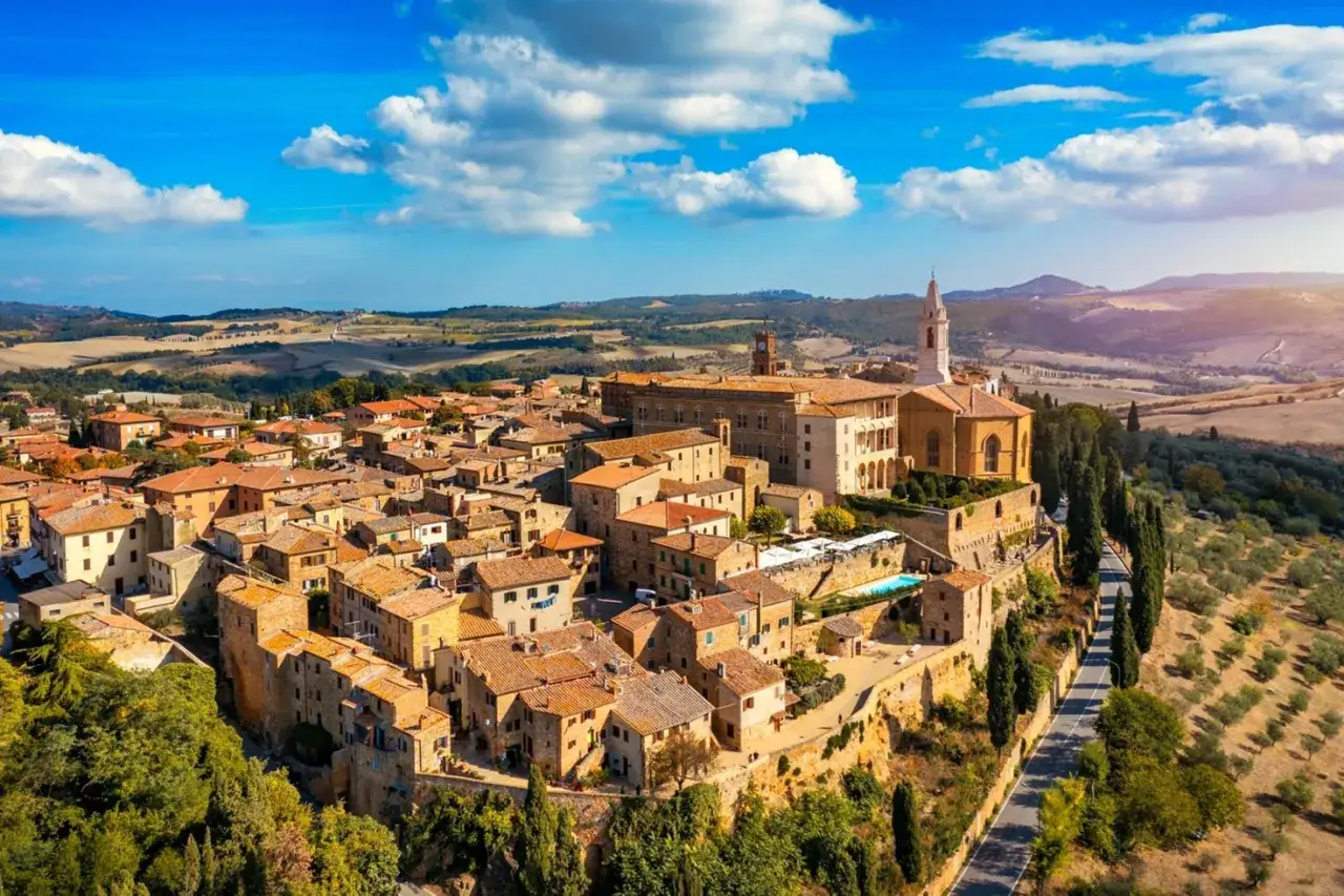 Un borgo medievale arroccato su una collina, con tetti in cotto e una chiesa imponente. Un assaggio di cosa vedere in Val d'Orcia, tra colline ondulate e cipressi.
