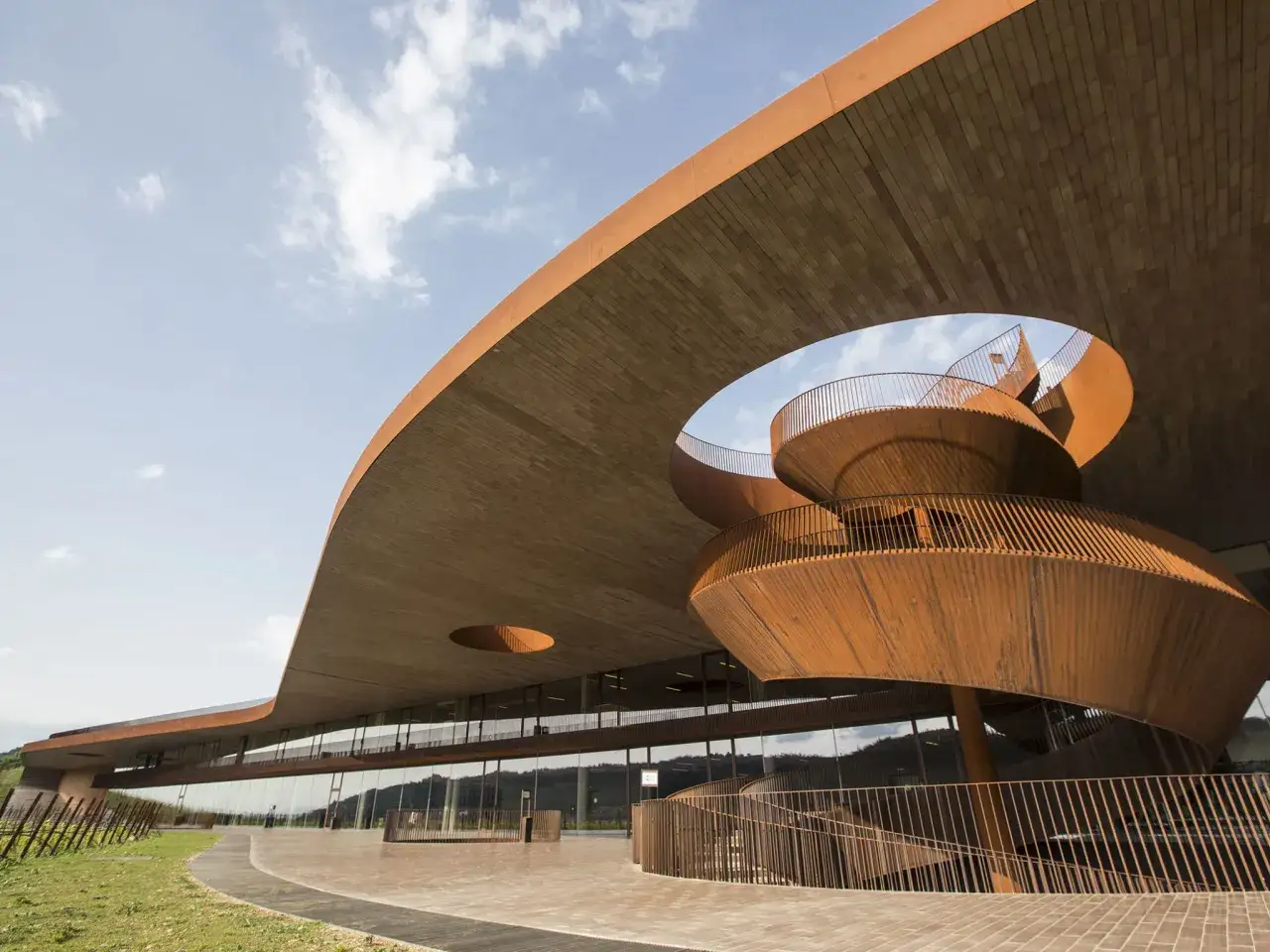 Cantine toscana famose: architettura moderna con scala a chiocciola in corten e tetto a sbalzo, che si integra nel paesaggio collinare.