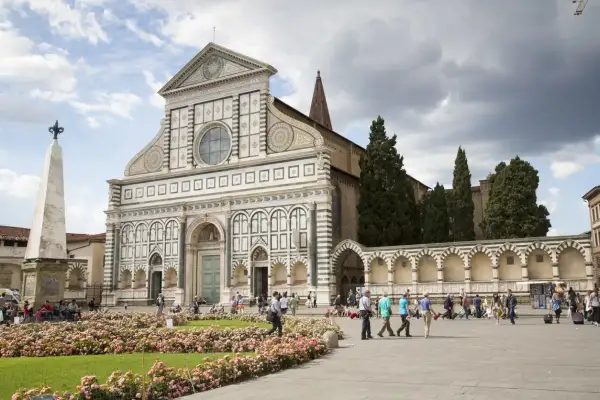 Piazza Santa Maria Novella, uno dei luoghi da vedere a Firenze, con la sua facciata rinascimentale e un prato fiorito.