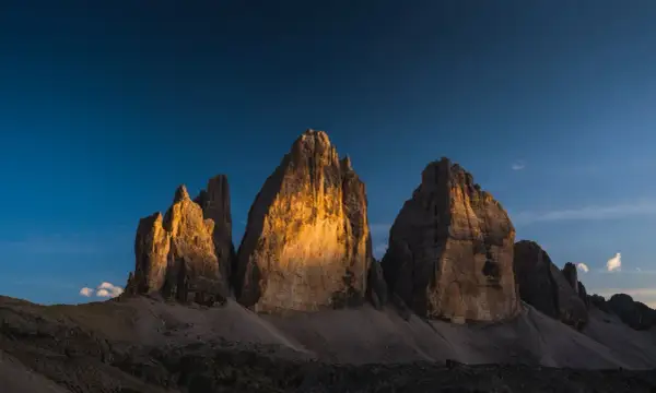 Le Tre Cime di Lavaredo illuminate dal sole al tramonto, un'idea perfetta per posti in montagna da visitare in giornata.
