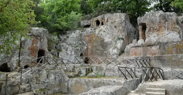 Antiche tombe etrusche scavate nella roccia, con sentieri e recinzioni in legno. Un suggestivo scorcio della mappa dei siti etruschi in Toscana.