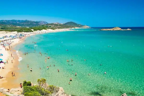 La spiaggia più bella della Sardegna, con sabbia dorata, acque cristalline e tante persone che si godono il sole e il mare.