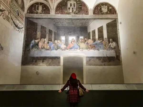 La donna ammira il cenacolo di Leonardo, un'opera d'arte che cattura l'intensità del momento.