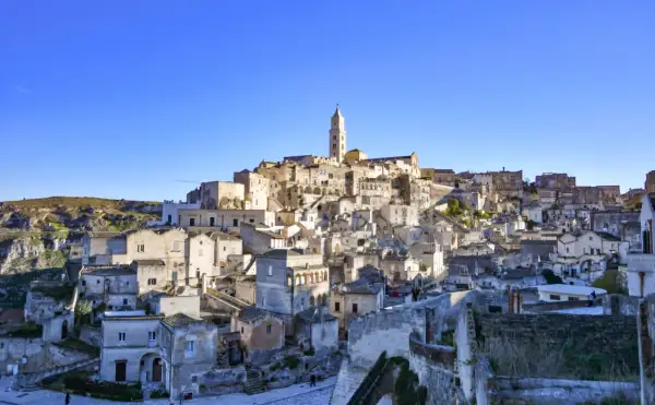 Panoramica dei Sassi di Matera, un labirinto di case scavate nella roccia, con indicazioni visive che guidano attraverso questo sito UNESCO.